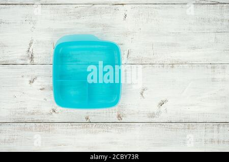 Empty plastic lunch box with sections on a white-washed wooden background. Space for text or your product. Top view, flat lay. Stock Photo