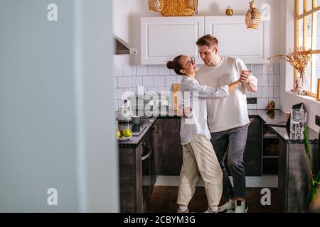 beautiful couple in love, they spend free time together at home, dance in the kitchen. cute couple happy together, have harmonious relationships Stock Photo