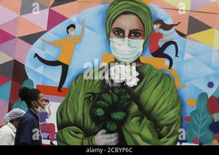 Sao Paulo, Brazil. 16th Aug, 2020. Medics pass by a graffiti painted on a wall to honor health workers amid COVID-19 outbreak at a hospital in Sao Paulo, Brazil, on Aug. 16, 2020. Credit: Rahel Patrasso/Xinhua/Alamy Live News Stock Photo