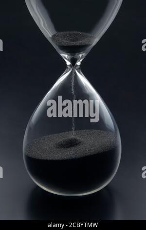 Hourglass on a dark background. Time is money. Business solutions in time. Stock Photo