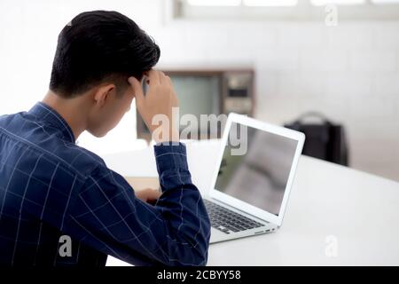 Young asian business man headache during working on laptop computer display blank screen with deadline at home, businessman with failure exhausted, st Stock Photo
