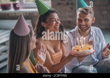 Woman blowing out candles during the birthday party Stock Photo