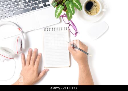business man hand writing on blank notebook  with laptop  and coffee isolated on white  background, top view and copy space Stock Photo