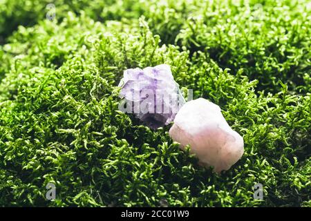 Amethyst and rose quartz on beautiful moss background. Magic stones for rituals, meditation and spiritual practices. Soft focus. Stock Photo