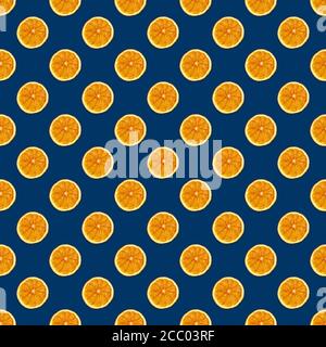 Flat lay Christmas seamless pattern made with dried orange fruit on blue background. Stock Photo