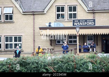 Wansford, UK. 15th Aug, 2020. Train enthusiasts watch as The Nene Valley Railway have resumed running steam trains from Wansford to Peterborough after the COVID-19 Coronavirus pandemic forced them to stop during lockdown. The 92 Squadron Battle of Britain 34081 steam train has been prepared and is ready to go, with the carriages having their capacity reduced to allow for new social distancing guidelines. Credit: Paul Marriott/Alamy Live News Stock Photo