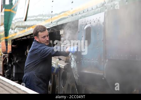 Wansford, UK. 15th Aug, 2020. Jamie Bond ensures the engine is very clean as The Nene Valley Railway have resumed running steam trains from Wansford to Peterborough after the COVID-19 Coronavirus pandemic forced them to stop during lockdown. The 92 Squadron Battle of Britain 34081 steam train has been prepared and is ready to go, with the carriages having their capacity reduced to allow for new social distancing guidelines. Credit: Paul Marriott/Alamy Live News Stock Photo