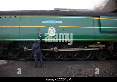 Wansford, UK. 15th Aug, 2020. Jamie Bond cleans the locomotive to make it look perfect as the Nene Valley Railway have resumed running steam trains from Wansford to Peterborough after the COVID-19 Coronavirus pandemic forced them to stop during lockdown. The 92 Squadron Battle of Britain 34081 steam train has been prepared and is ready to go, with the carriages having their capacity reduced to allow for new social distancing guidelines. Credit: Paul Marriott/Alamy Live News Stock Photo