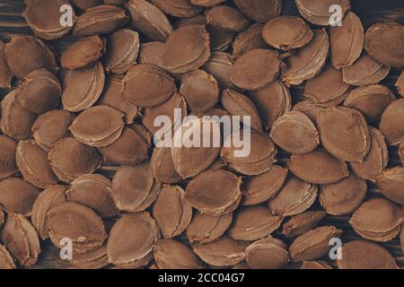 Top view of apricot pits  on a rustic wooden scratched board Stock Photo