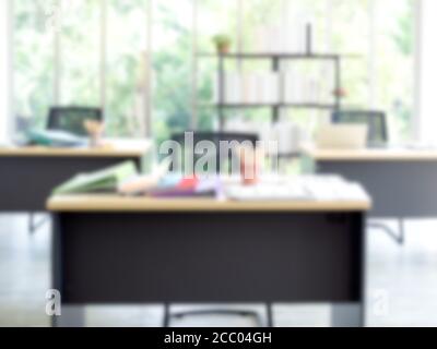 Blurred modern office interior background. Blurry well-lit workplace with laptop computer and document file folders on desk with bookshelf in the back Stock Photo