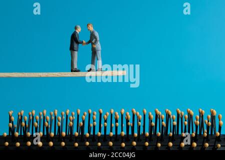 Miniature business concept - two businessman make partnership strategy for risk management transfer Stock Photo