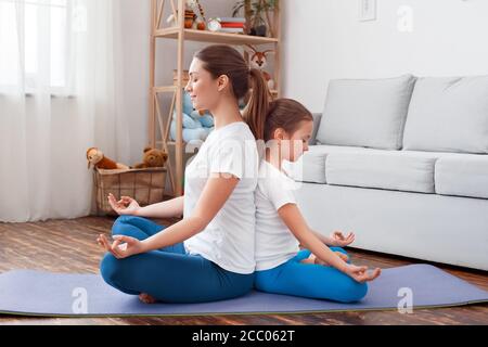 Little Girl Doing Prayer On Yoga Mat At Home Photo Background And