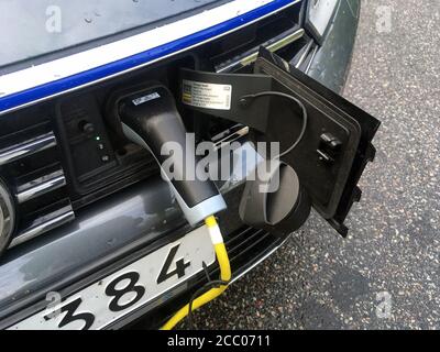 Stockholm, Sweden - September 15, 2015: A Swedish electric car being charged. A yellow cable is visible and the charger placed in the charge socket. Stock Photo