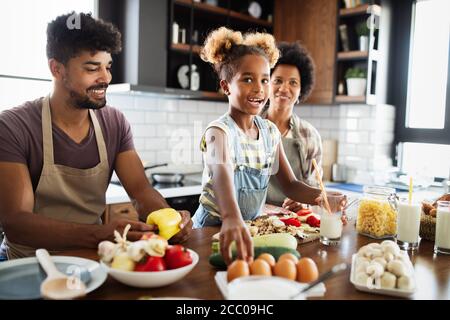 Happy family cooking together food in the kitchen Stock Photo