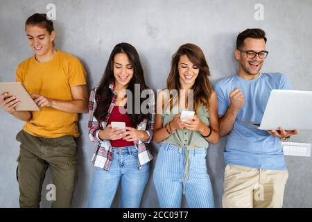 Education, technology and people concept. Happy group of friends using digital devices Stock Photo