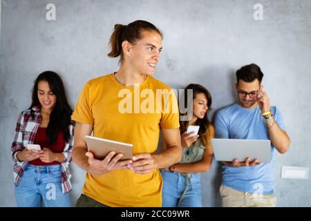 Education, technology and people concept. Happy group of friends using digital devices Stock Photo