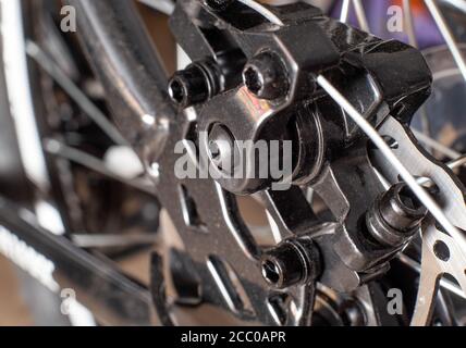 Brake system of a caliper and a metal brake disc on a bicycle, background, macro, chrome Stock Photo