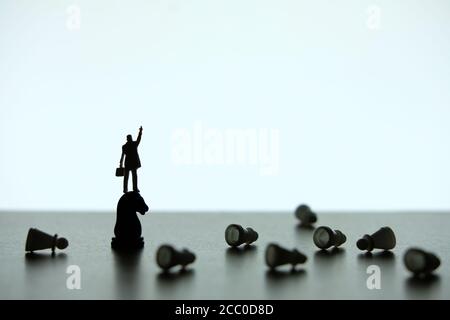 Business strategy conceptual photo - Silhouette of miniature businessman pointing upside, standing on a chess piece of horse Stock Photo