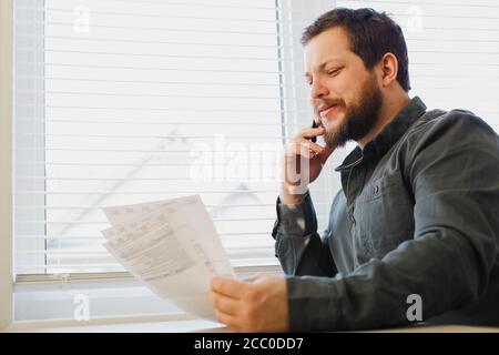 Broker reading documents at cabinet, holding papers and pen. Stock Photo