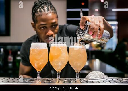 Johannesburg, South Africa - November 15, 2017: African Bartender pouring a Fruity cocktail at bar counter Stock Photo