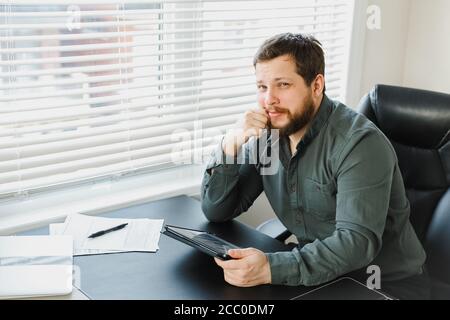 Successful male broker using digital tablet and working with documents. Stock Photo