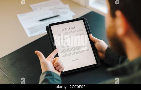 Man showing contract template on tablet. Stock Photo