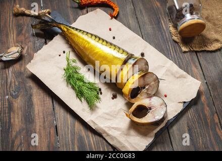 slices of smoked fish mackerel or scomber on a wooden table Stock Photo