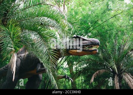 Dinosaur statue in the forest park / Spinosaurus dinosaur or spiny lizard Stock Photo