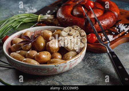 Grilled homemade sausage with young potatoes and green onions. Stock Photo
