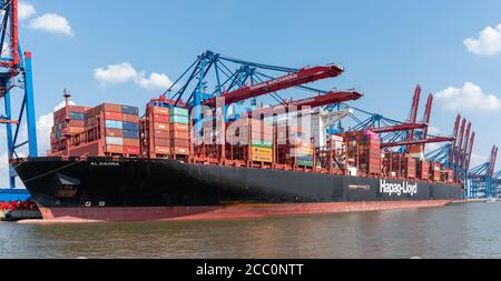 08-16-2020 Hamburg, Germany: Large container ship and container gantry cranes in port of Hamburg. AL DAHNA is a 400 meter long vessel operatred by