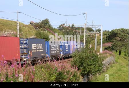 Container train from Daventry to Mossend passing Tebay and starting the climb to Shap Summit on the WCML in Cumbria on Saturday 15th August 2020. Stock Photo