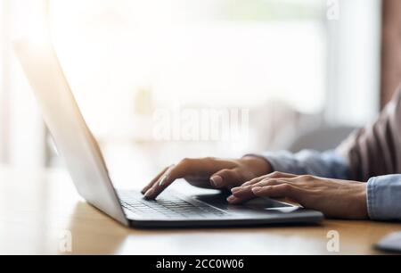 Unrecognizable woman typing on laptop at cafe Stock Photo
