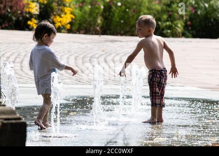 Children play in the water fountains in Priory Street, Coventry. The fountains situated between the university, Cathedral and Herbert art gallery rise and fall and are a feature of the city centre. Coventry is to become city of culture in 2021. Stock Photo