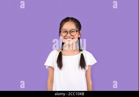 Asian Kid Girl Wearing Eyeglasses Smiling Posing Over Purple Background Stock Photo