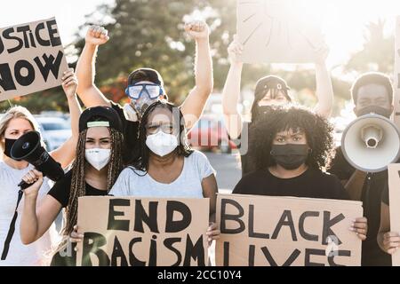 People from different ages and races protest on the street for equal rights - Demonstrators wearing protective masks during black lives matter fight c Stock Photo