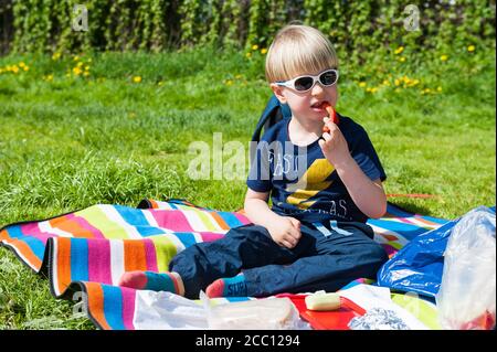 4 year old boy eating vegetables Stock Photo