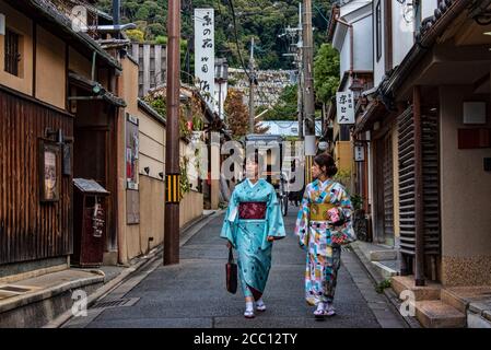 Two women in kimono strolling in Gion quarter street, Higashiyama, Kyoto, Japan Stock Photo