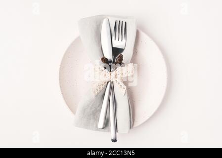 Beautiful set of cutlery knife and fork on a plate on a white wooden table. Stock Photo