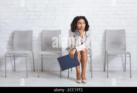 Bored African American woman in formal wear waiting for her job interview to start at corporate office, copy space Stock Photo