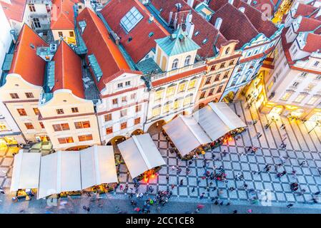 PRAGUE - SEPTEMBER 26, 2019: Aerial view of historical houses at Old Town Square with restaurant garden tents and many tourists. Colorful residential buildings with red rooftops. Prague, Czech Republic. Stock Photo