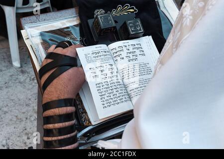 Orthodox Jewish man with tefillin and tallit, sitting alone and praying in  silence Stock Photo - Alamy