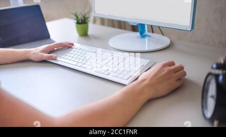 the developer works at the computer, typing, uses the mouse. Selective focus Stock Photo