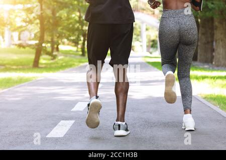 Personal Training Outdoors. Black Woman Running In Morning Park With Male Coach Stock Photo