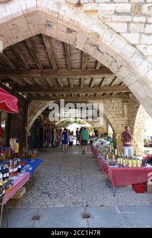 Monpazier, France 09 July 2020: Market stalls set up under the medieval arches in the town of Monpazier in France Stock Photo