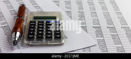 pencil and calculator  over financial spreadsheet table numbers.. Conceptual for accounting, budget, profit and financial Stock Photo