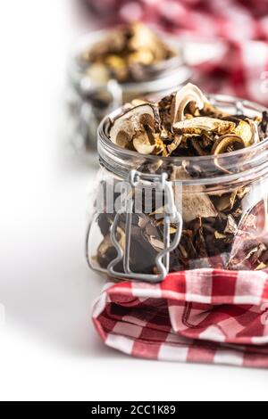 Dried mushrooms in a glass jar on a red checkered tablecloth Stock Photo