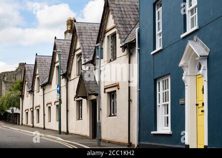 17th Century Montague Armshouses with castle behind. Chepstow, Monmouthshire, Wales, UK, Britain Stock Photo