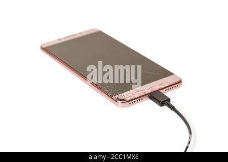 smartphone with broken screen charging via cable isolated on white background Stock Photo