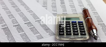 calculator and pencil over financial spreadsheet table numbers.. Conceptual for accounting, budget, profit and financial Stock Photo