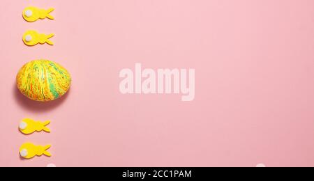 Yellow velvet bunnies and easter eggs on pink background on the left side with space for text. Flat lay top view. Easter concept Stock Photo